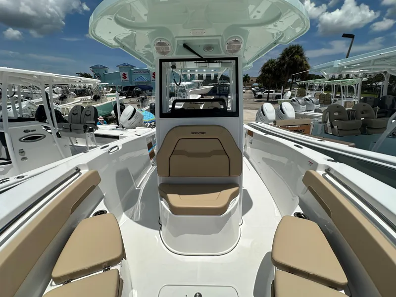 Slide: The Image of 2026 Sea Pro 262 Center Console boat with beige seating, docked under a sunny sky. - 6