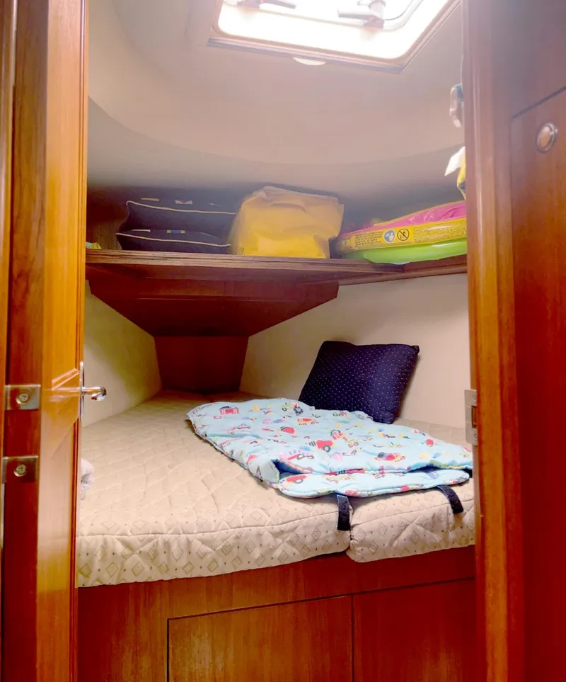 Slide: The Image of Cozy cabin interior of 2005 Hunter 38 sailboat with bedding and storage. - 10