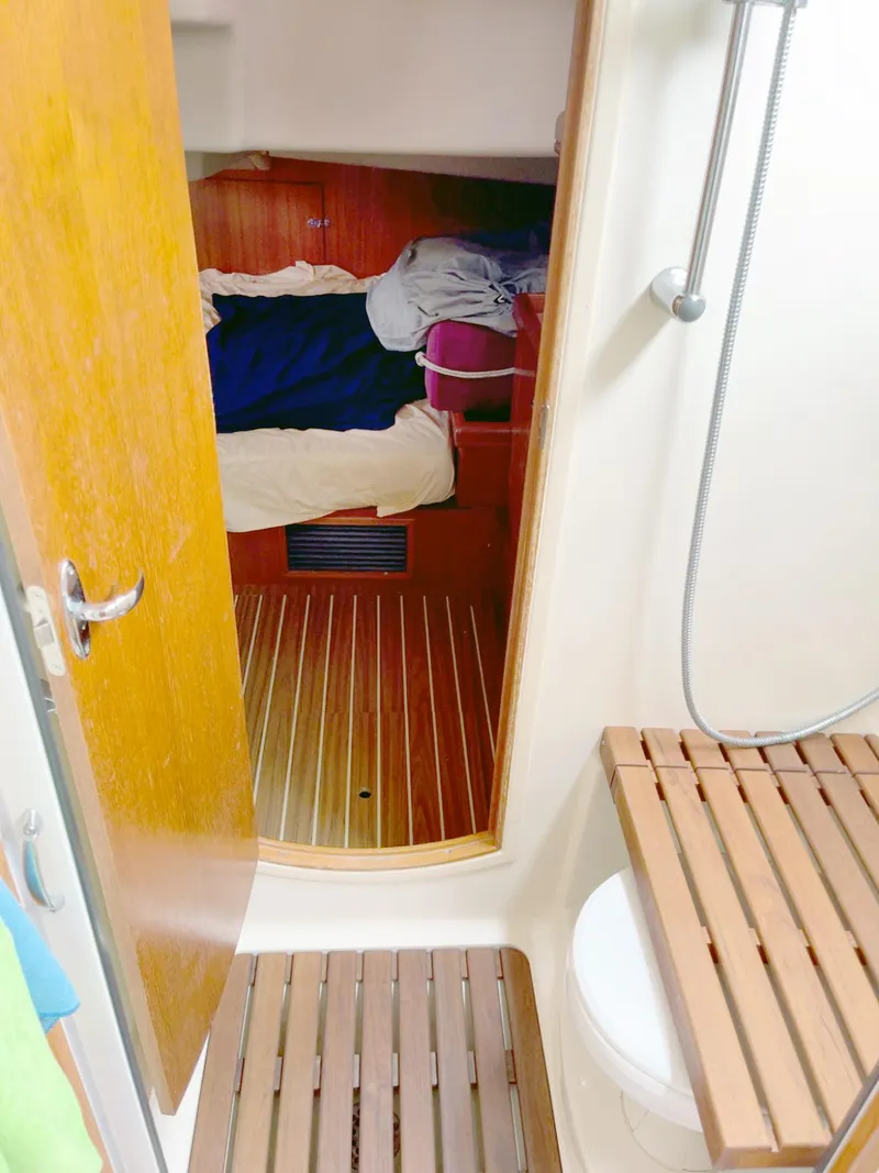 Slide: The Image of Interior of 2005 Hunter 38 sailboat showing cabin and bathroom with wooden flooring. - 9