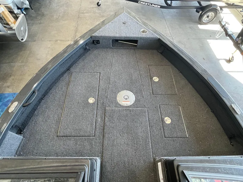 Slide: The Image of 2025 Crestliner 2050 Fish Hawk boat interior with carpeted deck and storage compartments. - 15