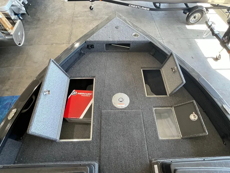 Slide: The Image of 2025 Crestliner 2050 Fish Hawk boat interior with storage compartments and Mercury box. - 16