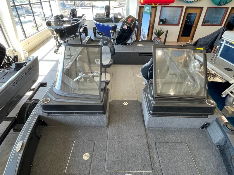Slide: The Image of 2025 Crestliner 2050 Fish Hawk boat interior with dual consoles and seating in showroom. - 18