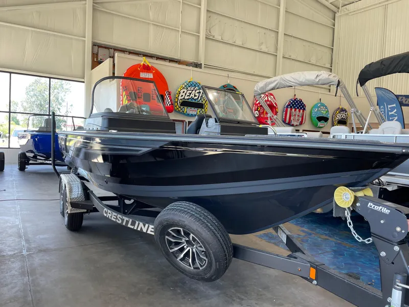 Slide: The Image of 2025 Crestliner 2050 Fish Hawk boat in showroom, black exterior, on trailer. - 2
