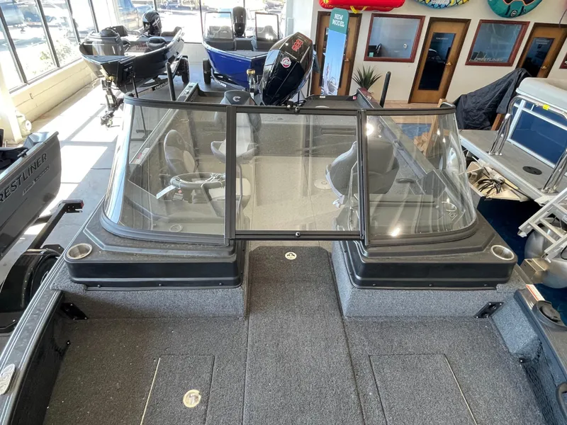 Slide: The Image of 2025 Crestliner 2050 Fish Hawk boat interior with windshield and seating in showroom. - 20