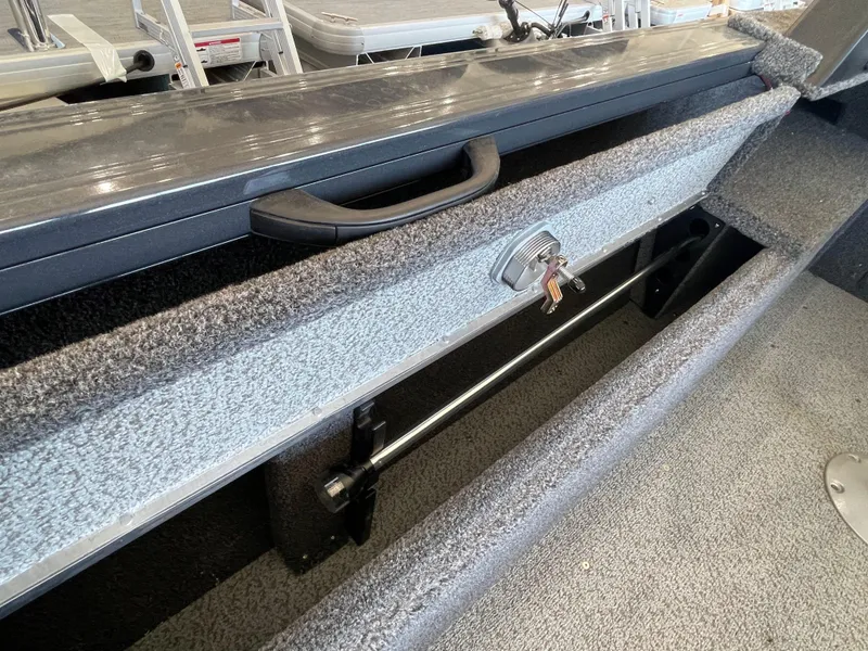 Slide: The Image of Storage compartment in 2025 Crestliner 2050 Fish Hawk boat, featuring secure lock and handle. - 6