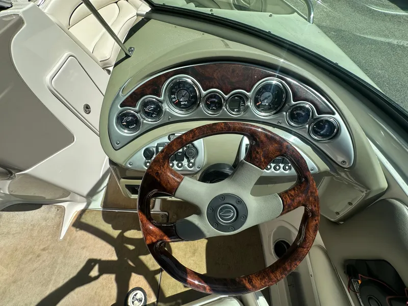 Slide: The Image of 2007 Crownline 220 LS boat dashboard with wood-accented steering wheel and instrument panel. - 11
