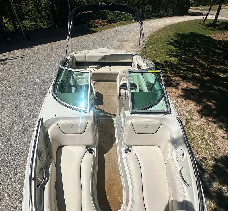 Slide: The Image of 2007 Crownline 220 LS boat with open seating and windshield, parked on a gravel path. - 32