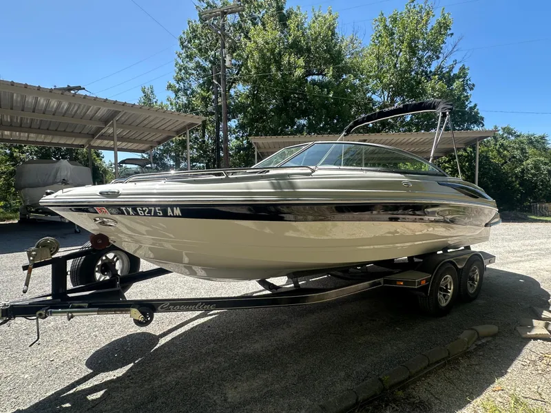Slide: The Image of 2007 Crownline 220 LS boat on trailer, parked outdoors under a canopy. - 7