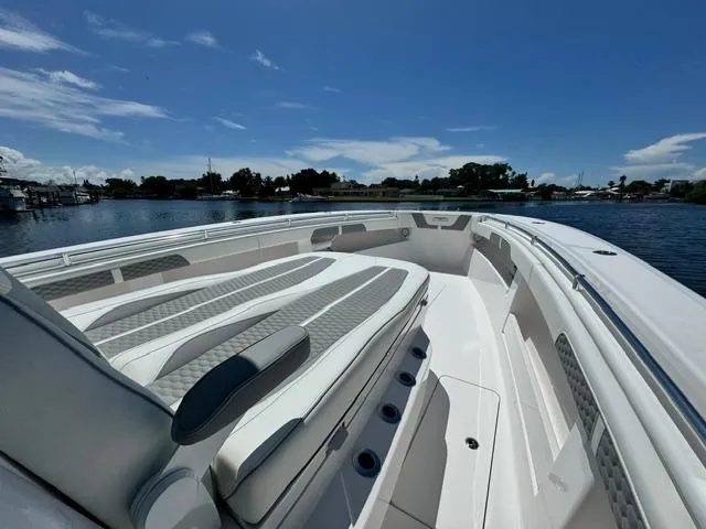 Slide: The Image of 2025 Invincible 39 Open Fisherman boat with sleek seating, on calm water under blue sky. - 12
