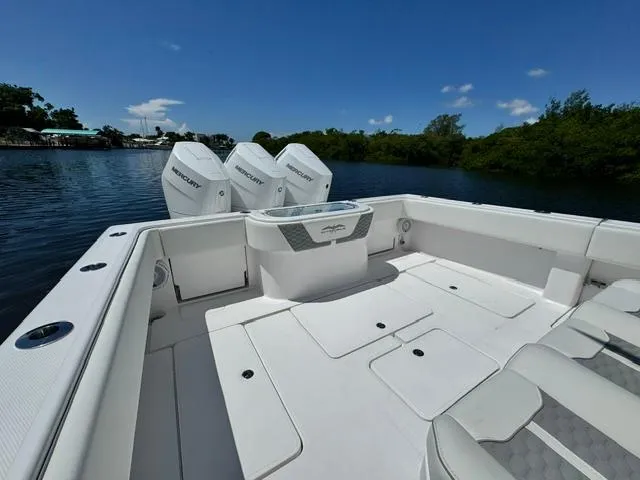 Slide: The Image of 2025 Invincible 39 Open Fisherman boat with triple Mercury engines on a calm lake. - 24