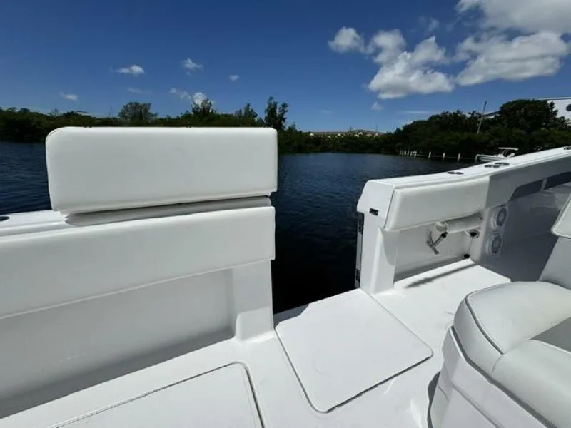 Slide: The Image of 2025 Invincible 39 Open Fisherman boat interior with white seating, near calm water. - 25