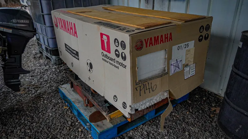 Slide: The Image of Cardboard box labeled Yamaha outboard motor on a pallet, gravel floor, G3 1548 VBW 2025. - 9