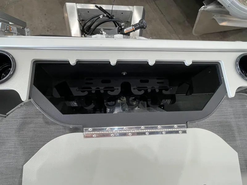 Slide: The Image of Interior view of 2026 Godfrey Xperience 2086 FX boat, showcasing storage compartment and cup holders. - 16