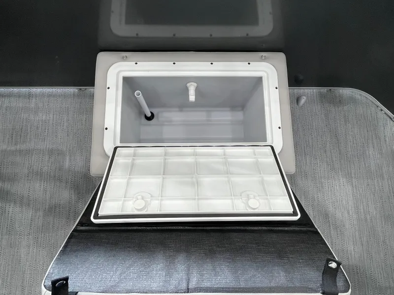 Slide: The Image of Open storage compartment on 2026 Godfrey Xperience 2086 FX boat, featuring a built-in cooler. - 17