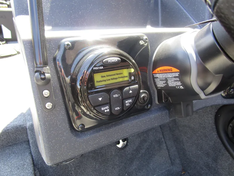 Slide: The Image of Control panel of 2026 Tracker Targa V18 Combo boat with audio system and warning label. - 7