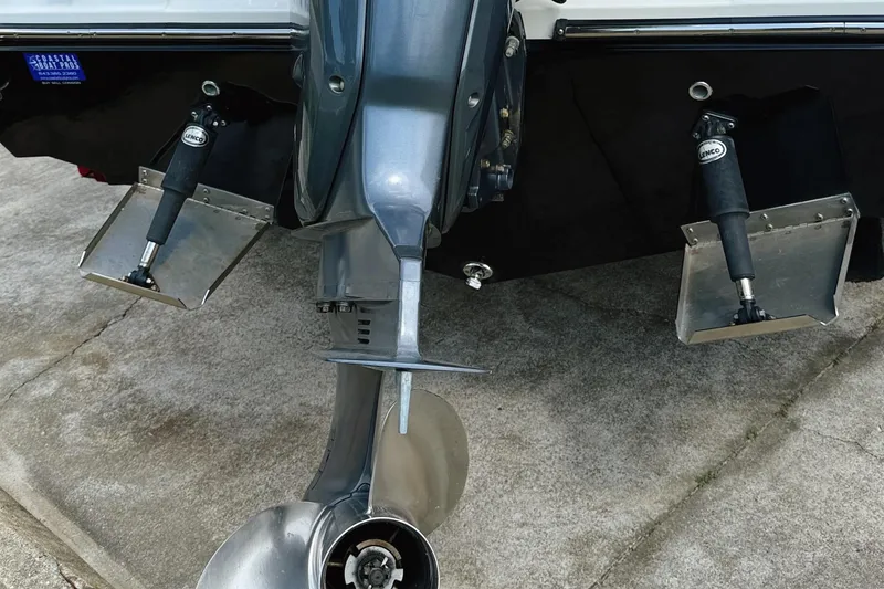 Slide: The Image of 2012 Cobia 217 Center Console boat engine and trim tabs on concrete surface. - 14