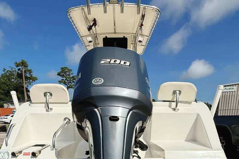 Slide: The Image of 2012 Cobia 217 Center Console boat with Yamaha 200 engine, under clear blue sky. - 15