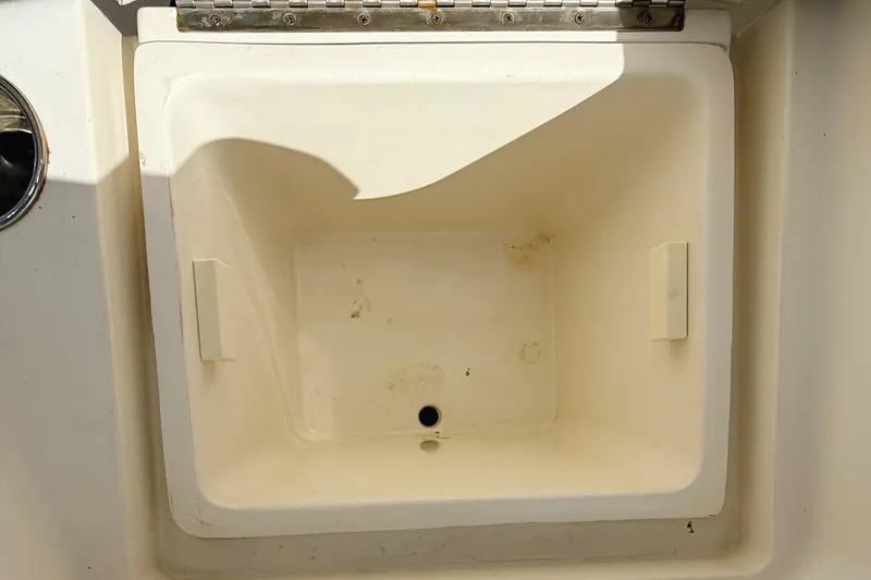 Slide: The Image of Open storage compartment on a 2012 Cobia 217 Center Console boat. - 16