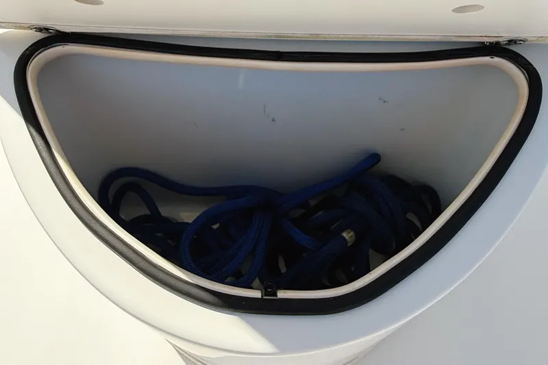 Slide: The Image of Open storage compartment with blue rope on a 2012 Cobia 217 Center Console boat. - 18