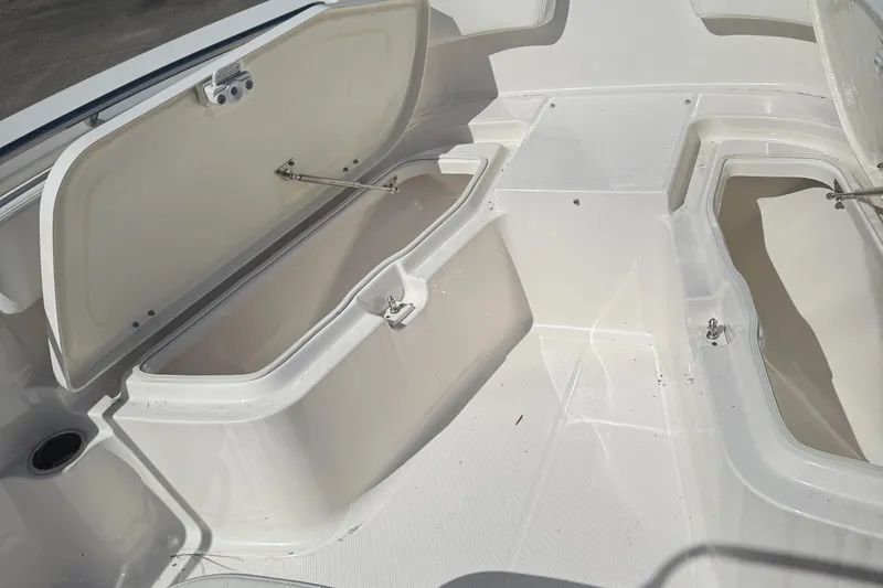 Slide: The Image of 2025 Robalo R200 Center Console boat storage compartments open, showcasing spacious interior design. - 12