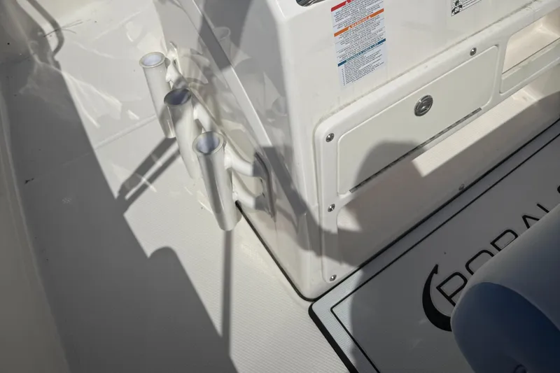 Slide: The Image of 2025 Robalo R200 Center Console boat interior with rod holders and storage compartment. - 7