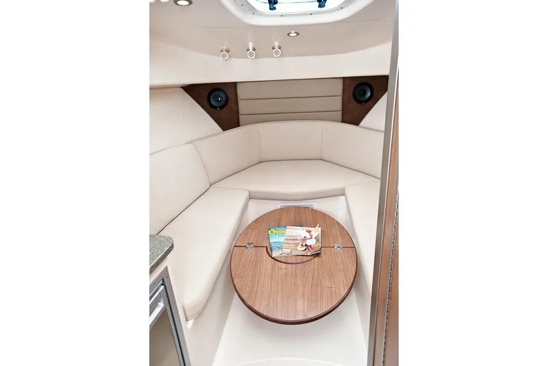 Slide: The Image of Manufacturer Provided Image: 2019 Boston Whaler 285 Conquest cabin interior with beige seating and wooden table. - 19