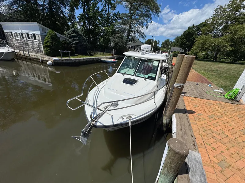 Slide: The Image of 2019 Boston Whaler 285 Conquest docked by a wooden pier on a sunny day. - 24