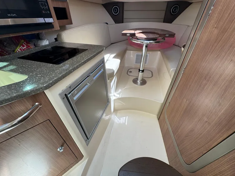 Slide: The Image of 2019 Boston Whaler 285 Conquest cabin interior with kitchenette and seating area. - 39