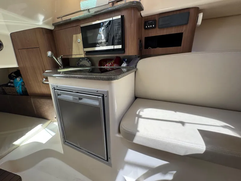 Slide: The Image of Interior of a 2019 Boston Whaler 285 Conquest boat with kitchenette and seating area. - 40