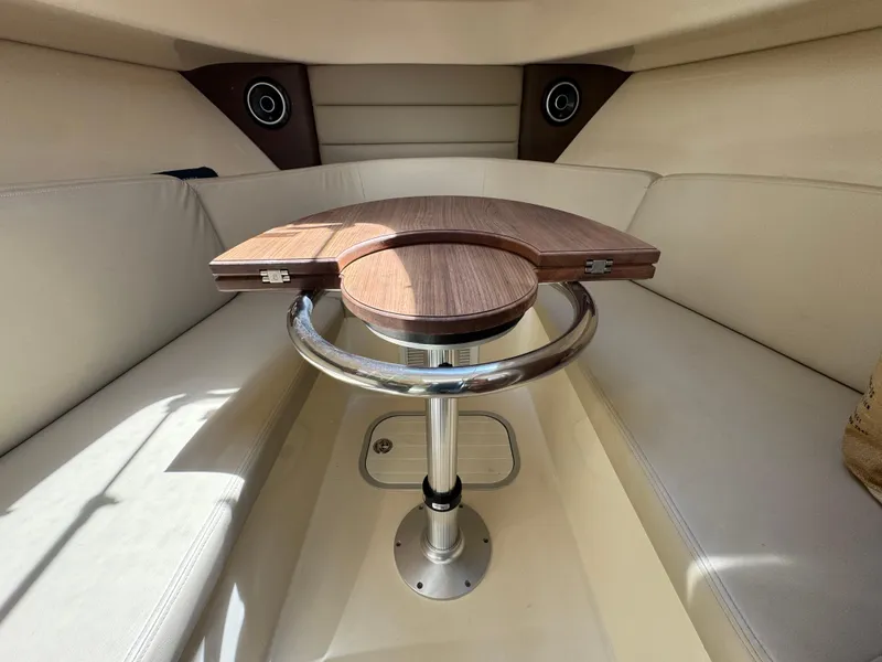 Slide: The Image of Interior of 2019 Boston Whaler 285 Conquest with foldable wooden table and cushioned seating. - 42