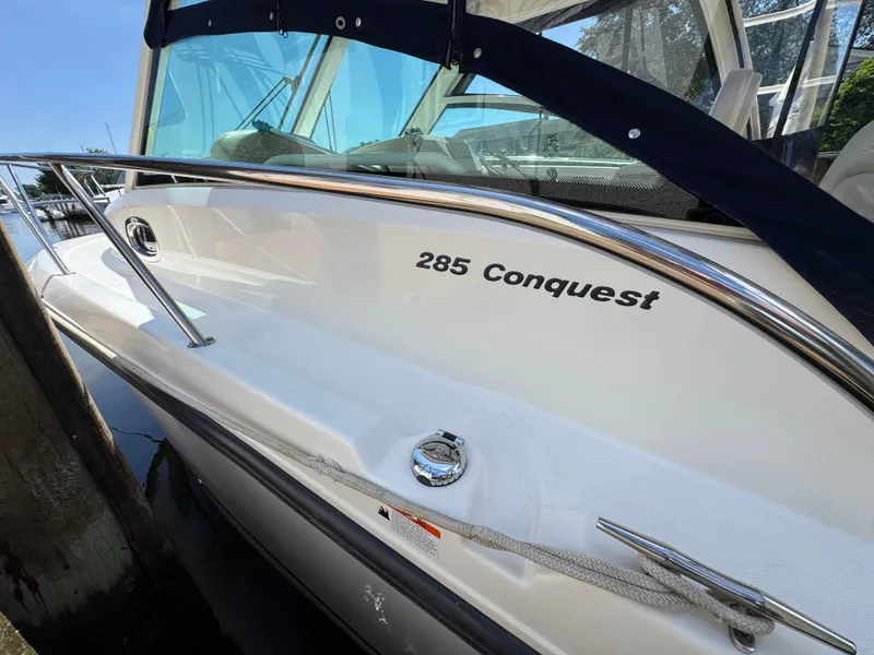 Slide: The Image of 2019 Boston Whaler 285 Conquest boat docked, showcasing sleek design and railing. - 45