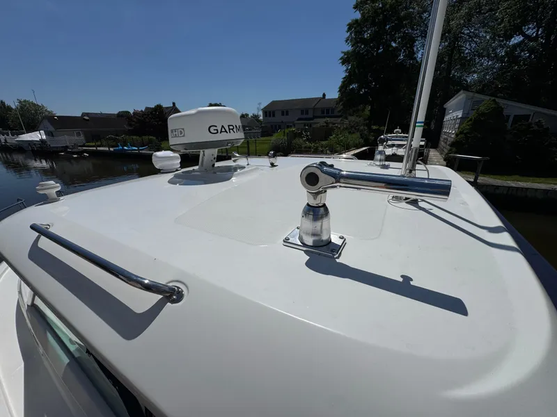 Slide: The Image of 2019 Boston Whaler 285 Conquest boat deck with Garmin radar, docked near waterfront homes. - 46