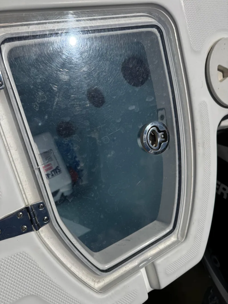 Slide: The Image of 2019 Boston Whaler 285 Conquest cabin window with visible lock mechanism. - 47