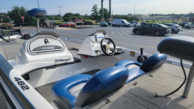 Slide: The Image of 2006 Nitro 482 DC boat interior with blue seats, parked in a lot. - 5