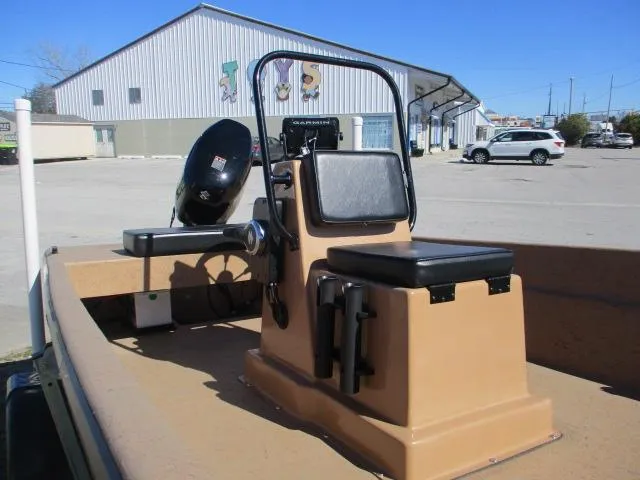 Slide: The Image of 2023 Rabco 16 Buccaneer boat interior with steering console and seat, parked outdoors. - 13