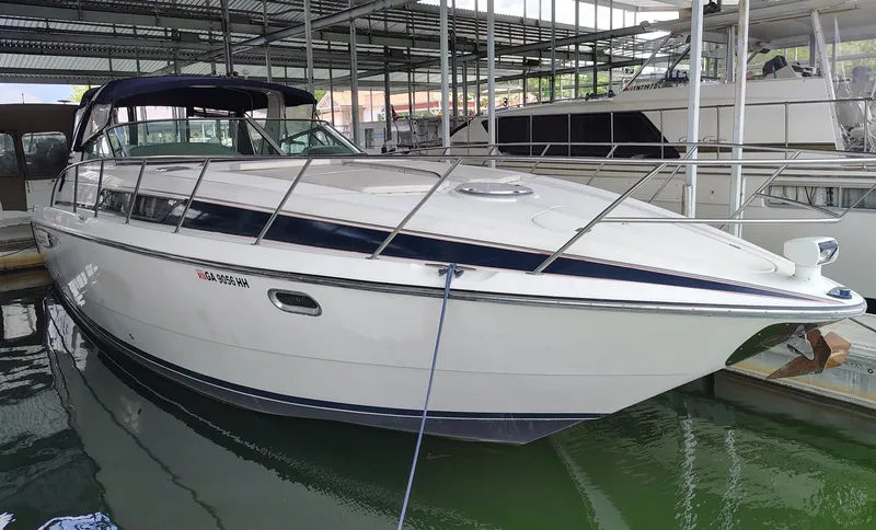 Slide: The Image of 1997 Bayliner 4085 Avanti yacht docked in a marina under a covered shelter. - 0