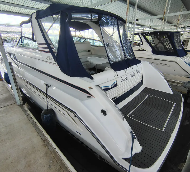 Slide: The Image of 1997 Bayliner 4085 Avanti yacht docked, featuring blue canopy and spacious deck. - 10