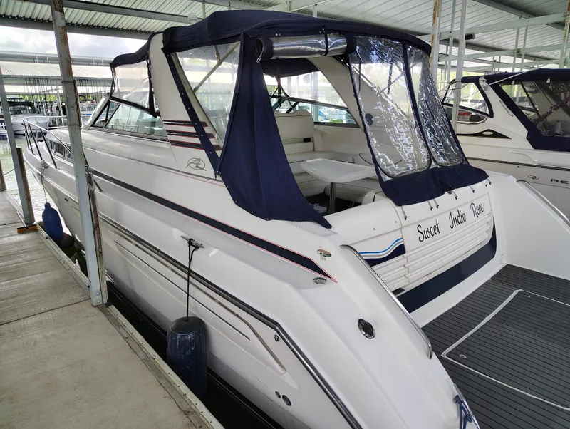 Slide: The Image of 1997 Bayliner 4085 Avanti yacht docked, featuring blue canopy and sleek white design. - 13