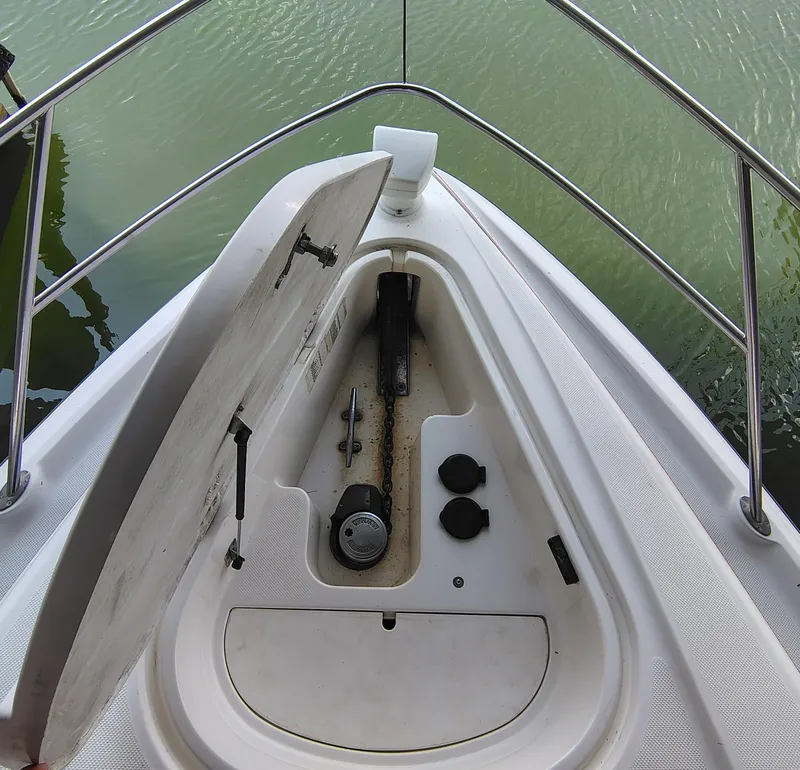 Slide: The Image of 1997 Bayliner 4085 Avanti boat anchor compartment with open hatch, showing chain and fittings. - 16