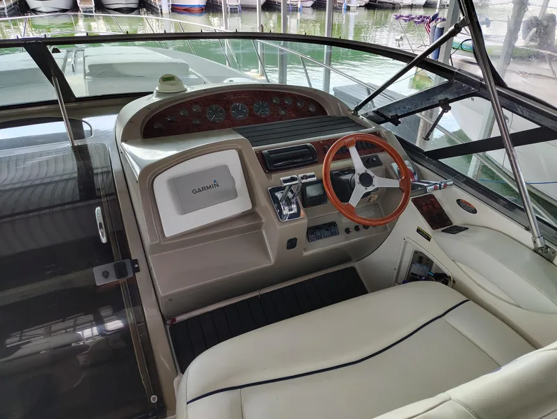 Slide: The Image of 1997 Bayliner 4085 Avanti helm with Garmin navigation, wooden steering wheel, and leather seating. - 27
