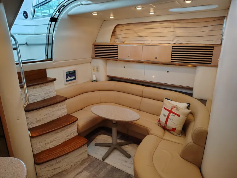 Slide: The Image of 1997 Bayliner 4085 Avanti interior with beige seating, wooden steps, and nautical decor. - 32