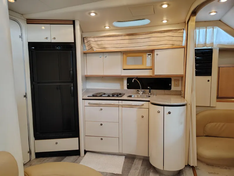 Slide: The Image of 1997 Bayliner 4085 Avanti yacht interior kitchen with modern appliances and sleek cabinetry. - 33