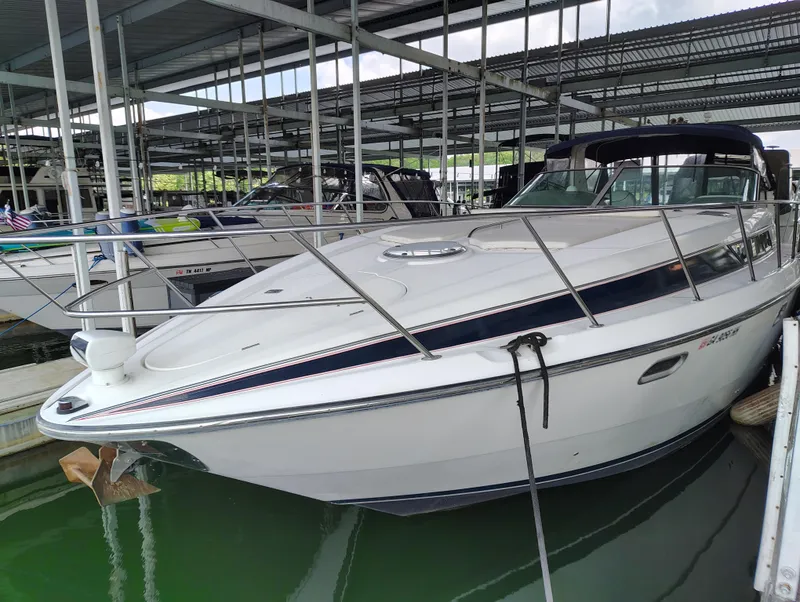 Slide: The Image of 1997 Bayliner 4085 Avanti docked in a marina under a covered structure. - 5