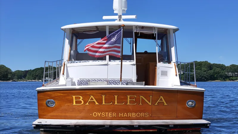 Slide: The Image of 2002 Grand Banks 49 Eastbay HX boat named Ballena on water, American flag waving. - 10