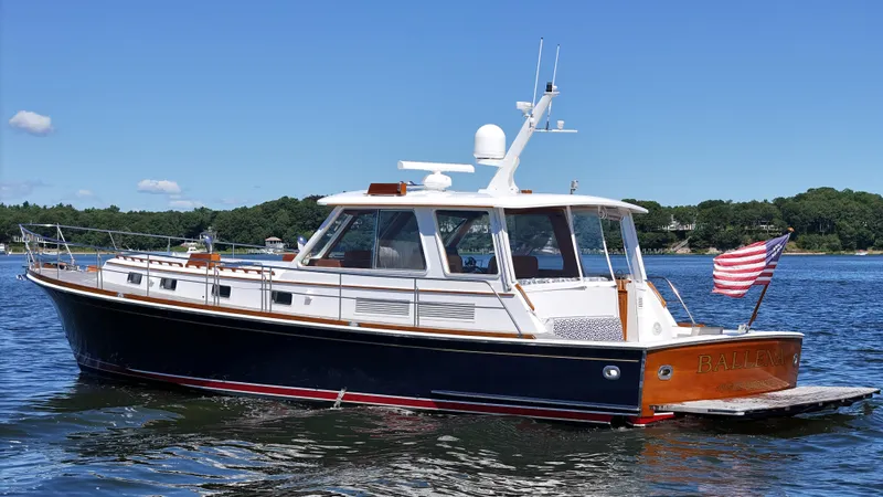 Slide: The Image of 2002 Grand Banks 49 Eastbay HX yacht on calm water with American flag. - 12