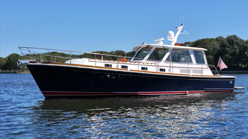 Slide: The Image of 2002 Grand Banks 49 Eastbay HX yacht on calm water, clear sky background. - 2