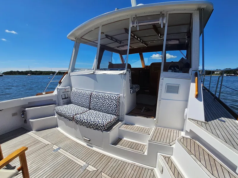 Slide: The Image of 2002 Grand Banks 49 Eastbay HX yacht with spacious deck and seating, docked on a sunny day. - 20