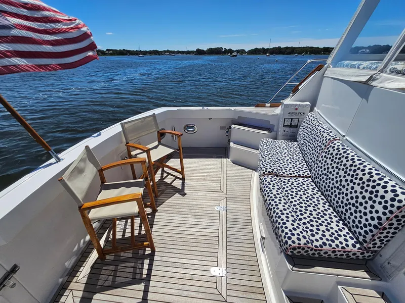 Slide: The Image of 2002 Grand Banks 49 Eastbay HX yacht deck with seating, chairs, and American flag. - 22