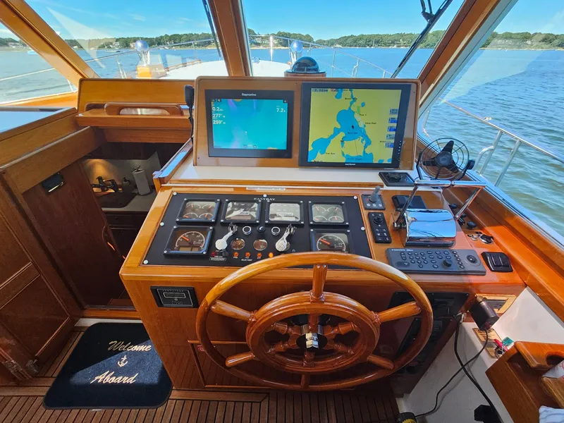 Slide: The Image of Helm of 2002 Grand Banks 49 Eastbay HX with navigation screens and wooden steering wheel. - 27
