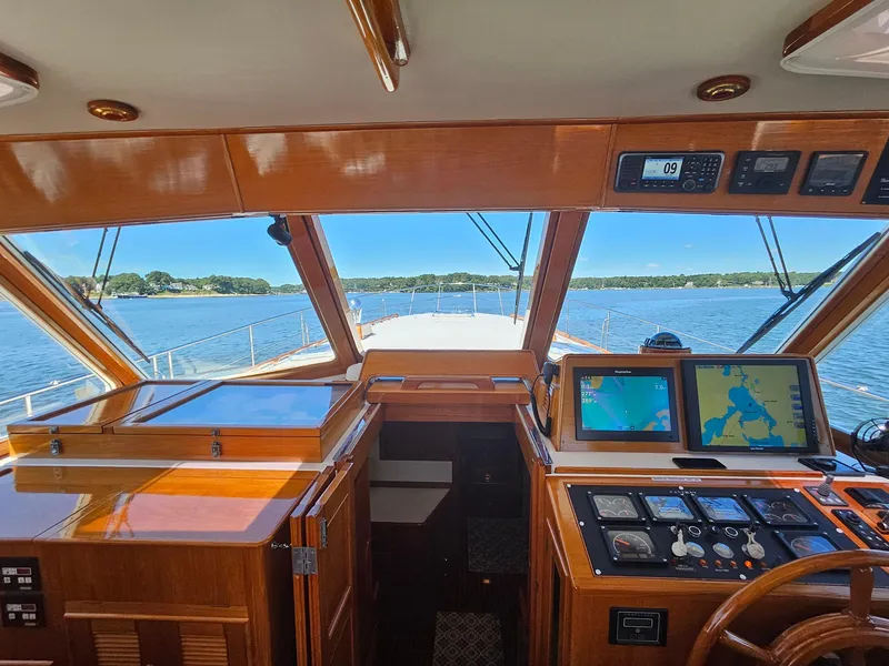 Slide: The Image of 2002 Grand Banks 49 Eastbay HX helm with navigation screens, overlooking serene waters. - 31
